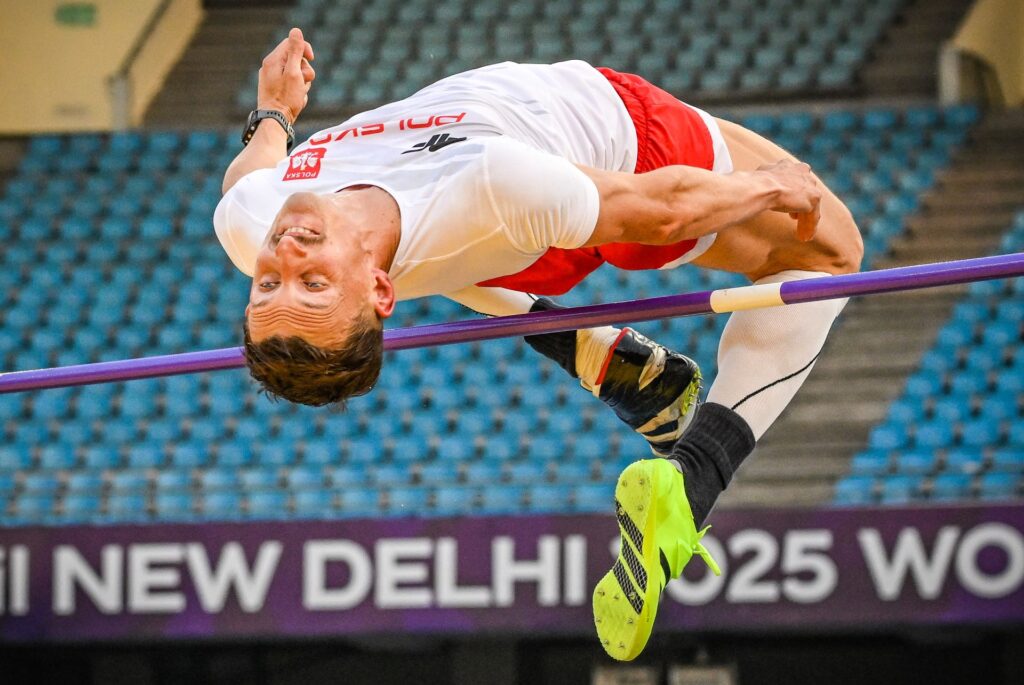 Maciej Lepiato przelatuje nad poprzeczką na stadionie w New Delhi