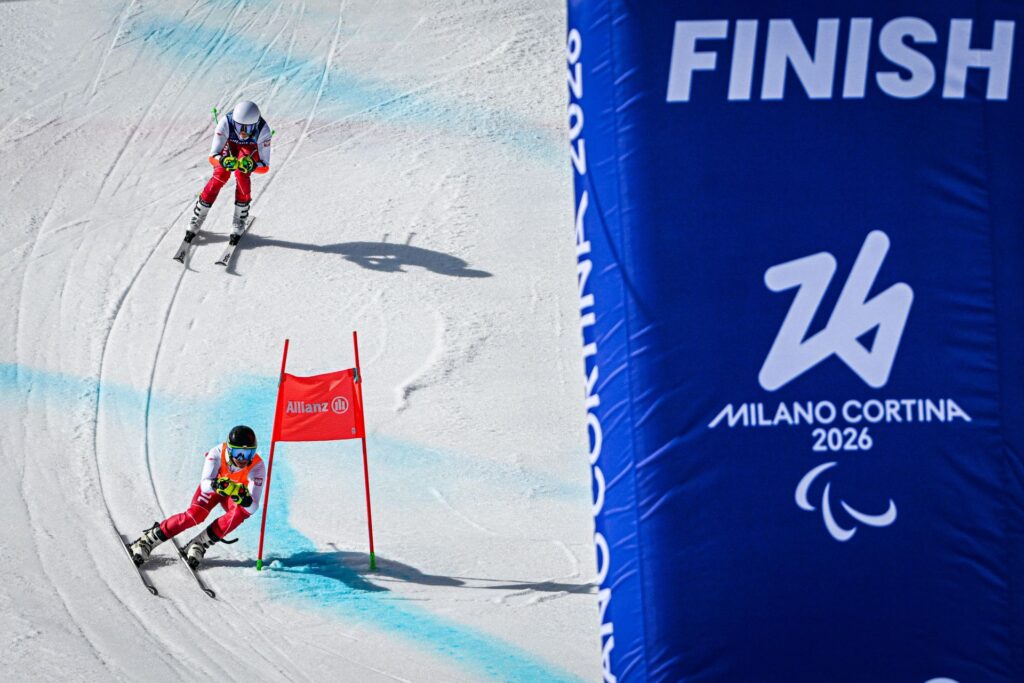 Michał Gołaś i Kacper Walas mijają na śniegu bramkę, pędząc na nartach do mety