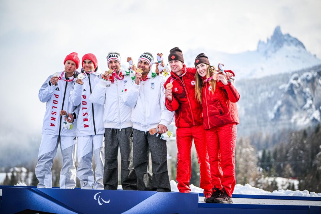 Sześcioro medalistów, czyli zawodnicy z przewodnikami, na podium prezentuje medale