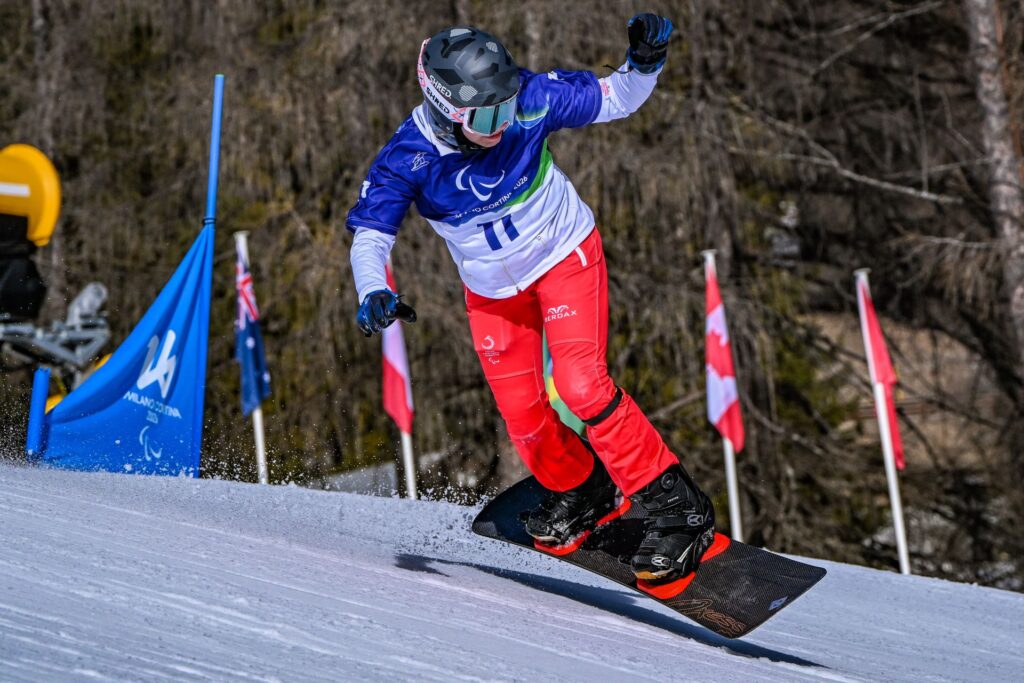 Natalia Siuba-Jarosz na desce snowboardowej w lekkim wyskoku, leci nad zaśnieżonym stokiem