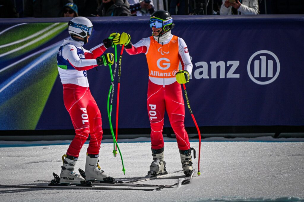 Michał Gołaś i Kacper Walas na mecie stojąc na nartach przybijają sobie tzw. żółwika