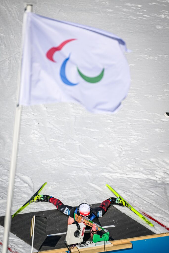 Błażej Bieńko na biathlonowej strzelnicy leży celując z karabinu