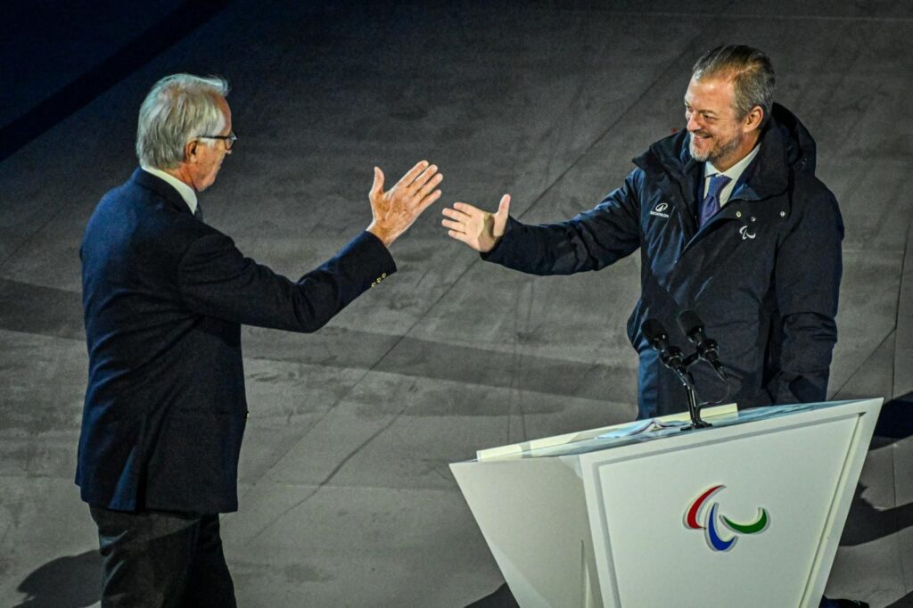 Andrew Parsons i Giovanni Malago przy mównicy przybijają tzw. piątkę